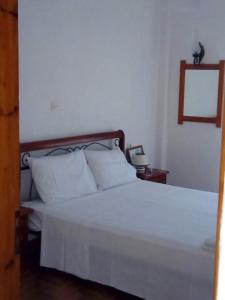 una camera da letto con un letto con lenzuola bianche e un telefono di Kassandra Garden Residence a Istron