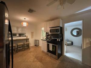 a kitchen with a stove top oven in a room at Hot tub, tiki bar, outdoor shower, near Intercoastal Waterway! in West Palm Beach