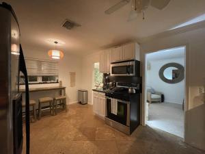 a kitchen with a stove top oven in a room at Hot tub, tiki bar, outdoor shower, near Intercoastal Waterway! in West Palm Beach