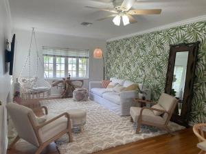 a living room with a white couch and chairs at Hot tub, tiki bar, outdoor shower, near Intercoastal Waterway! in West Palm Beach