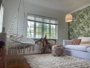 a living room with a swing and a couch at Hot tub, tiki bar, outdoor shower, near Intercoastal Waterway! in West Palm Beach
