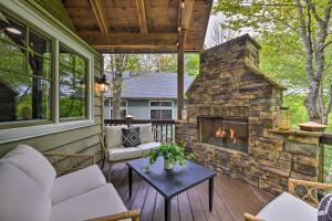 une véranda avec une cheminée en pierre dans l'établissement Stunning Cashiers Home with Deck and Outdoor Fireplace, à Cashiers