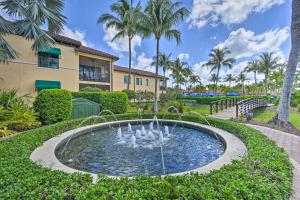 a fountain in front of a building with palm trees at Luxe Naples Bay Resort Condo Near Fifth Ave! in Naples