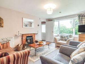 a living room with a couch and a fireplace at Cowmans Cottage in Aldeburgh