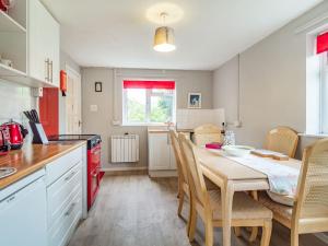 a kitchen and dining room with a table and chairs at Cowmans Cottage in Aldeburgh