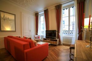 a living room with a red couch and a television at La Suite Lanterne in Lyon