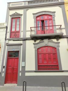 a building with red doors and a balcony at Adara Vegueta Exclusive Apartment in Las Palmas de Gran Canaria