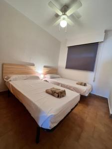 Cette chambre dispose de 2 lits et d'un ventilateur de plafond. dans l'établissement PUSHE Playa Velilla Beach&Tradition, à Almuñécar