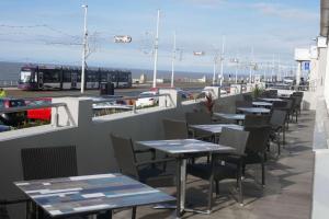 a row of tables and chairs on a patio with a bus at Best Western Carlton Hotel in Blackpool