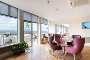 a room with chairs and a table and windows at Best Western Carlton Hotel in Blackpool