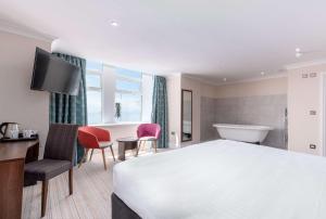 a hotel room with a bed and a bath tub at Best Western Carlton Hotel in Blackpool +121 photos