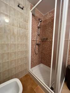 une salle de bain avec douche et toilettes dans l'établissement PUSHE Playa Velilla Beach&Tradition, à Almuñécar 13 autres photos