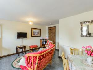 a living room with a couch and a tv at Yew Tree Cottage in Welshpool