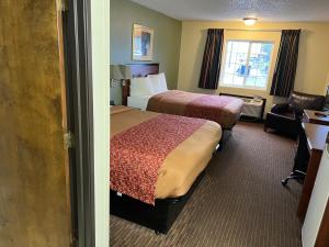 a hotel room with a bed and a desk at Thunderbird Lodge in Mitchell