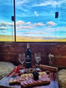una mesa con una botella de vino y dos copas en Bangalô do Amor, en Serra do Cipo