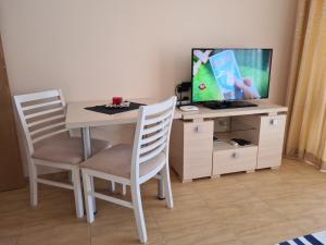 a dining room table with two chairs and a tv at Apart Hotel Aqua Dreams in Sveti Vlas