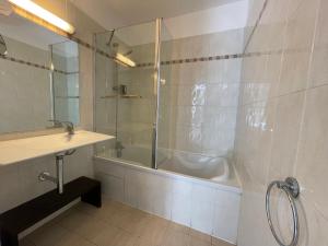 a bathroom with a tub and a sink and a shower at Appartement 321 avec deux chambres - LES SUITES DE ROBINSON - Résidence avec piscine en bord de Siagne, à Mandelieu-La-Napoule in Mandelieu-la-Napoule +1 photo