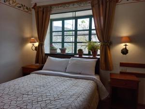 a bedroom with a large bed and a window at Hospedaje La Florida in Urubamba