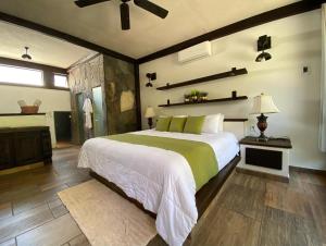 a bedroom with a large bed and a ceiling fan at Las Jaras Aguas Termales in La Garita