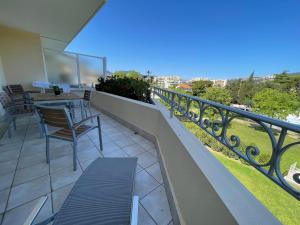 a balcony with a table and chairs on a balcony at Appartement 321 avec deux chambres - LES SUITES DE ROBINSON - Résidence avec piscine en bord de Siagne, à Mandelieu-La-Napoule in Mandelieu-la-Napoule