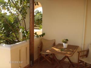a small table and chairs in a room with a window at Tompras Village in Paralia Demonias
