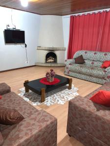 a living room with a couch and a fireplace at Recanto Benedetti, casa para temporada in Campos do Jordão