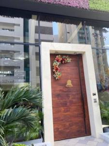 a wooden door with a wreath of flowers on it at Fabuloso apartamento en el Mar Caribe - Rodadero in Gaira