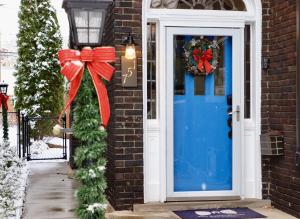 a blue door with a red bow and a wreath at The Butler House Bed & Breakfast in Niagara Falls