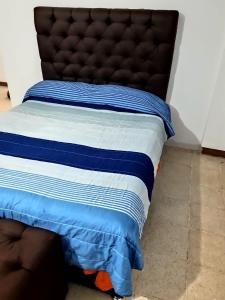 ein Bett mit einer blauen und weißen Bettdecke darauf in der Unterkunft CASA CERCA DE LA PLAYA in Puerto Escondido