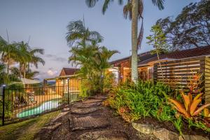 a house with a fence and a swimming pool at The Hillside Retreat in Mount Tamborine