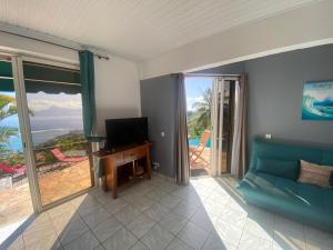 Televízia a/alebo spoločenská miestnosť v ubytovaní Globe trotter Lodge Tahiti