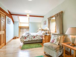 sypialnia z łóżkiem i krzesłem w obiekcie Y Bwthyn w mieście Llanegryn