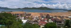 a small town next to a body of water at Divine Castle Travelers Inn in Coron