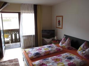 a bedroom with two twin beds and a television at Pension Sabine in Oberstaufen