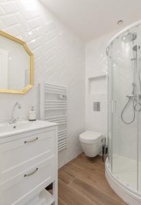 uma casa de banho branca com um chuveiro e um WC. em Echoppe typique de Bordeaux rénovée 3 ch./3 sdb em Talence