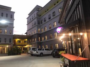 DD Residence Sai5 Salaya ห้องพัก ดีดี สาย5 ศาลายา في Ban Bang Rathuk: مبنى فيه سيارات تقف امامه