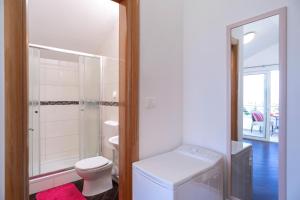 a white bathroom with a toilet and a sink at Villa Fio - Rooms & Studio in Hvar