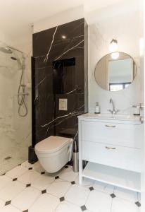 uma casa de banho com um WC, um lavatório e um espelho. em Echoppe typique de Bordeaux rénovée 3 ch./3 sdb em Talence