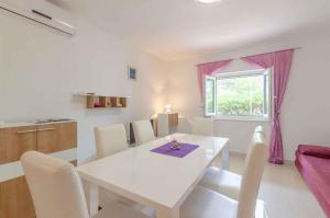 a white dining room with a white table and a window at Holiday home in Blato Insel Korcula 6411 in Prigradica