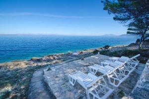 a group of white chairs sitting next to the ocean at Holiday home in Blato Insel Korcula 6411 in Prigradica