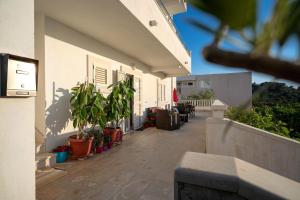 a porch of a house with potted plants on it at Villa Fio - Rooms & Studio in Hvar