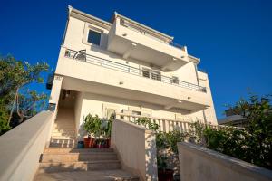 a white house with stairs in front of it at Villa Fio - Rooms & Studio in Hvar