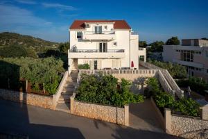 a white house with a fence in front of it at Villa Fio - Rooms & Studio in Hvar