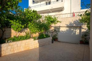 a driveway in front of a building with a garage at Villa Fio - Rooms & Studio in Hvar