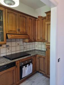uma cozinha com armários de madeira e um forno com placa de fogão em Appartamento Via Loreto em Pistoia