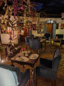 una sala de estar con sillas, mesas y flores en Hotel Boutique Amorini, en San Cristóbal de Las Casas