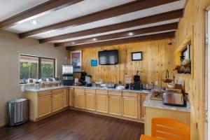 une grande cuisine avec des placards en bois et une télévision dans l'établissement Budget Lodge, à Ruidoso