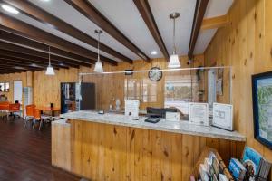 un restaurant avec des murs en bois et un comptoir avec une horloge dans l'établissement Budget Lodge, à Ruidoso