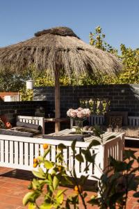 een patio met een tafel en een rieten parasol bij Hotel Costa Rica in Buenos Aires