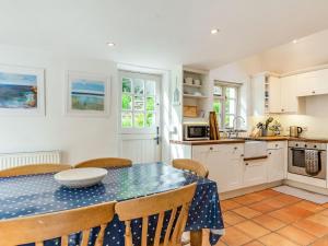 een keuken en eetkamer met een tafel en stoelen bij 3 Rose Cottages in St. Agnes 